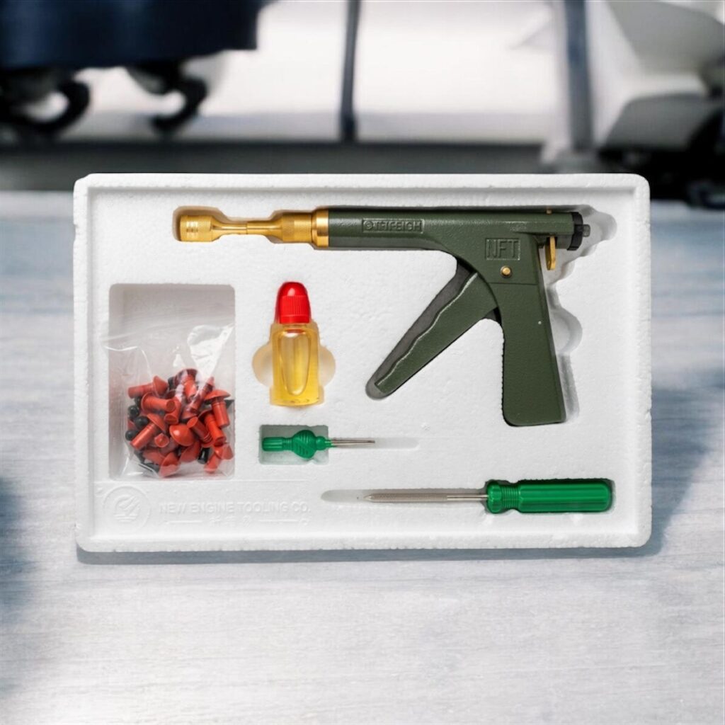 Un kit profesional de reparación rápida de neumáticos que incluye una pistola aplicadora mecánica verde y dorada, tapones cónicos de goma, lubricante y herramientas de inserción, todo organizado en una bandeja protectora a medida